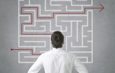 Man searching for a nonprofit accounting cheat sheet in a maze