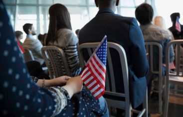 Woman holding American flag at town hall meeting