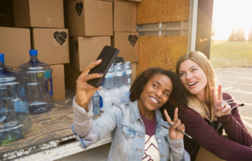 Two female volunteers taking a photo during a volunteer activity, showing the value of Instagram for nonprofits to help spread your mission