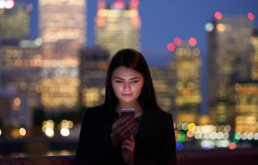 Millennial Girl Using a Smart Phone in a Big City